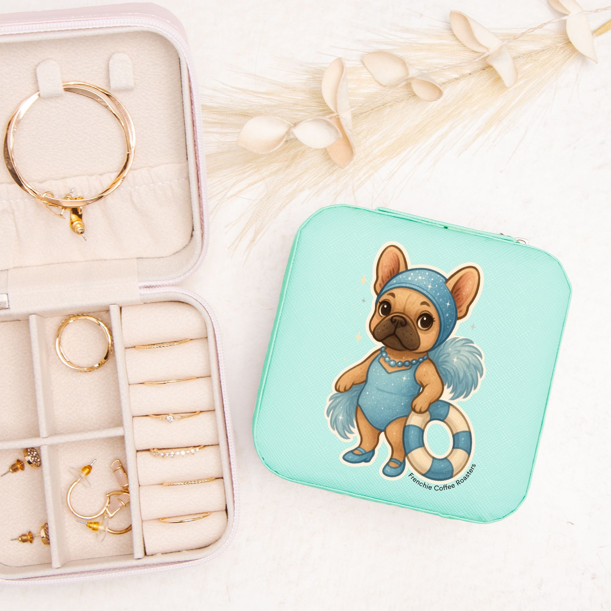 Teal jewelry travel case featuring a swimming French Bulldog illustration with organized velvet interior compartments