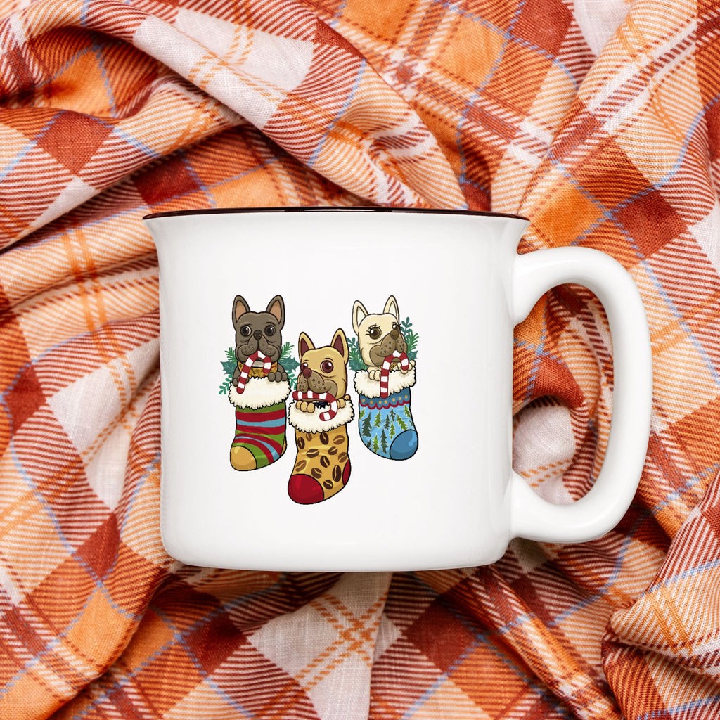 White mug with dog illustrations in Christmas stockings on a plaid fabric background