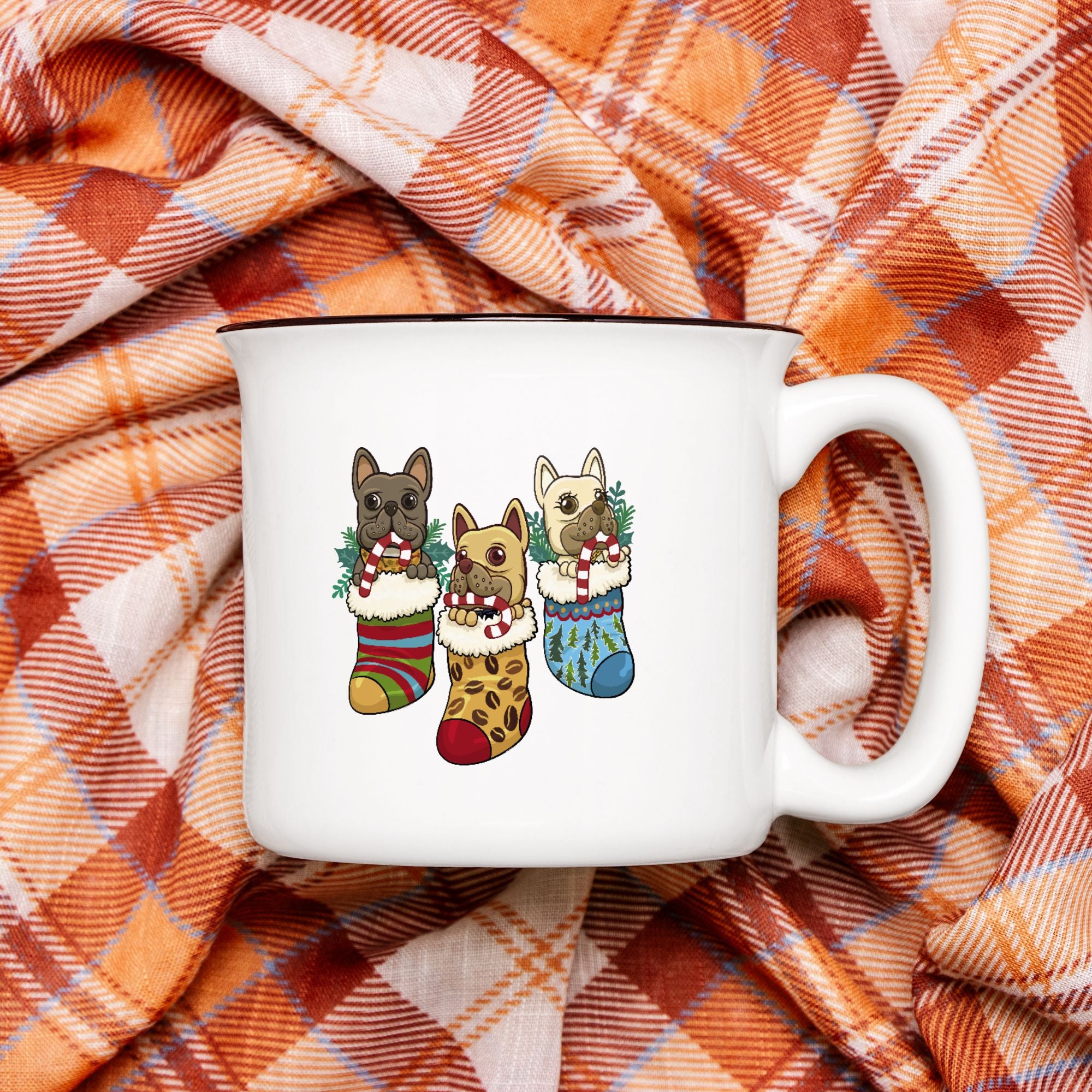 White mug with dog illustrations in Christmas stockings on a plaid fabric background
