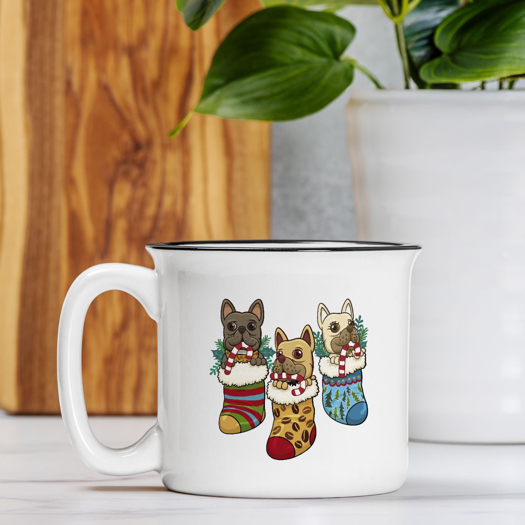 White mug with dog illustrations in Christmas stockings on a wooden surface.