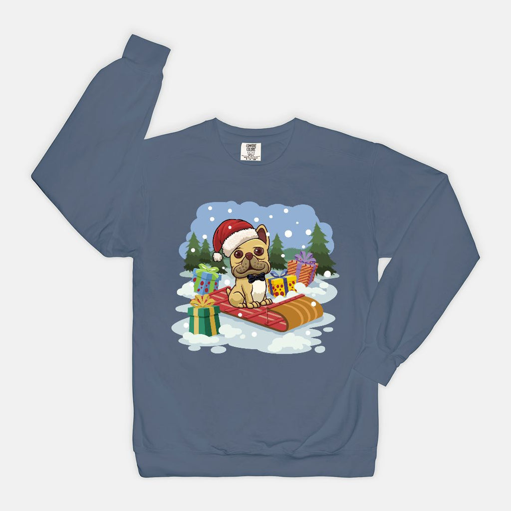 French Bulldog wearing a Santa hat sledding through snow on a blue crewneck sweatshirt from Frenchie Coffee Roasters holiday collection